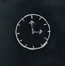 Chalk-drawn clock on a blackboard, symbolizing time and education concepts.